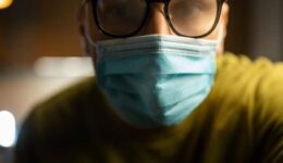 A person wearing glasses and a face mask with foggy lenses, indicating issues with mask-related fogging and dry eyes.